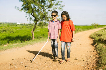 Teenager girl helping to blind brother by walking each other at mountain - concept of caregiver,friendship bonding and disability. - obrazy, fototapety, plakaty