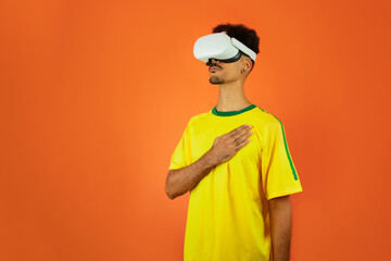 Brazilian Player - Black Man Celebrating With VR Virtual Glasses Isolated on Orange background