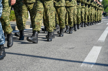 Soldiers in camouflage uniform and black boots marching in formation on parade. Special armed...