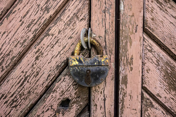 Old rusty vintage lock on a wooden door closeup