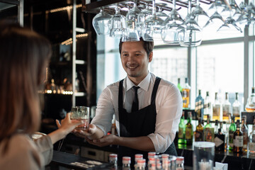 Bartender serve cocktail drink for customer at the bar in restaurant dinning at the party