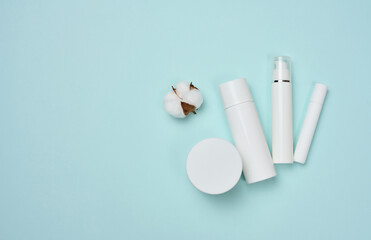 White plastic tubes  and jar for cream, gel and other cosmetics on a blue background