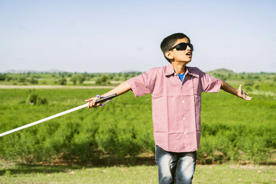 indian teeneger blind kid with eyeglasses enjoying nature and fresh air at mountain - concept of freedom, healthy lifestyle and wellness.