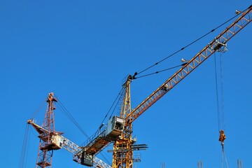 Fototapeta na wymiar View of construction cranes and reinforced concrete houses under construction