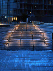 Cool, blue winter evening’s light is punctured by a warm glowing downlighters on an amphitheatre staircase at the redeveloped Battersea Power Station.