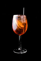 Aperol spritz preparado en coctelería con fruta y mucho hielo, listo para tomar en fondo negro