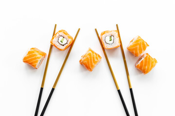 Salmon sushi rolls set with chopsticks on table, top view