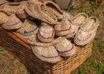 Bast shoes, woven from bast, close-up on the background of grass in summer