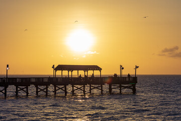 Sunset over an ocean pier in Port Isabel 