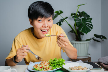 Asian woman happily On the dining table with Thai food, papaya salad and grilled chicken. Eat alone at home.