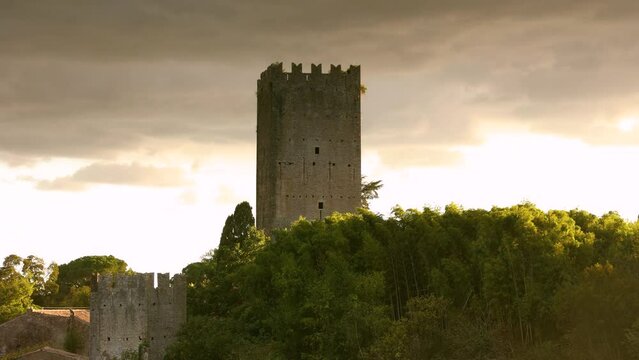 Time lapse at sunset of the castle tower of the garden of Ninfa in Cisterna di Latina, Norma, near Rome Italy. Much visited natural monument in Italy. Garden is in English style like the Kew Garden