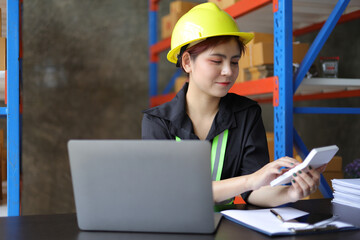 Small warehouse worker working with a laptop is checking the inventory. Entrepreneurs start-up e-commerce businesses working in the office.