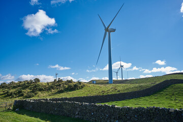 Three wind turbines shot in landscape, set against blue summer skies