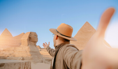 Travel Selfie photo man in hat background pyramid of Egyptian Giza and Sphinx, sunset Cairo, Egyp - obrazy, fototapety, plakaty