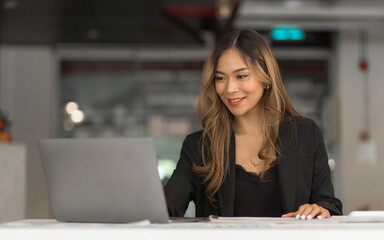 Confident asian businesswoman working  in office workstation.