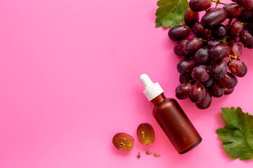 Obraz na płótnie Canvas Grape seed essential oil with bunch of grapes. Eco cosmetic product