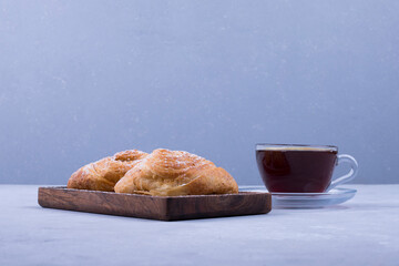 A cup of espresso with caucasian pastries on blue background