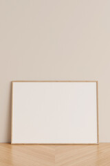 Clean and minimalist front view horizontal wooden photo or poster frame mockup leaning against wall on wooden floor. 3d rendering.