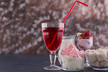 Marshmallows and turkish lokum in glass cups with a glass of red wine