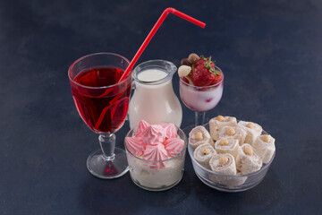 Marshmallows and turkish lokum in glass cups with a glass of red wine, milk and fruits