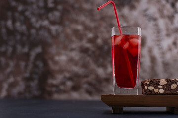 Red cocktail with ice cubes in a glass