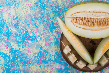 Slices and cubes of melon on a wooden platter