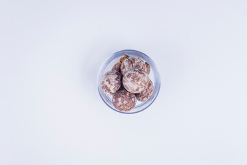 Cocoa gingerbreads in a glass cup on white background in the center