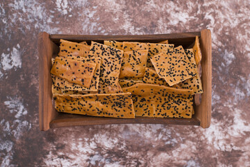 Obraz premium Crackers with black cumin on them in wooden tray in the center