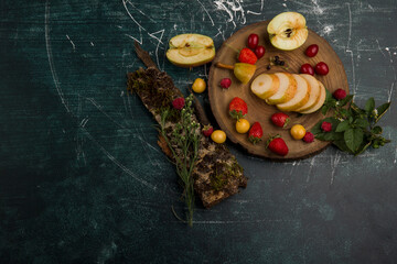 Round fruit platter with pears, apple and berries isolated on blue background, top view