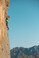 A woman climbs a rock