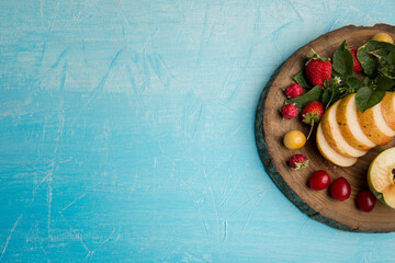 Round fruit platter with pears, apple and berries in the right side