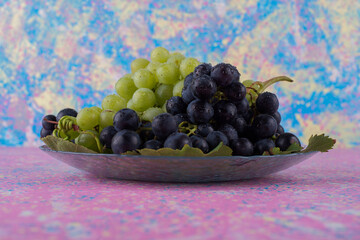 Red and green grape bunches in a platter