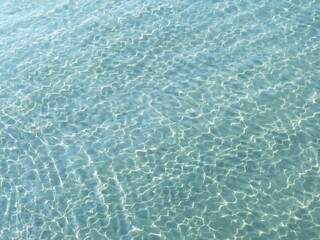 Water blue transparent clear surface with sunlight reflection.