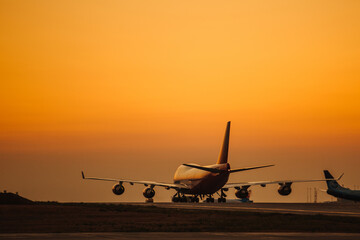 Passenger airplane take off from airport runway against the backdrop of a picturesque evening sky with sun rays