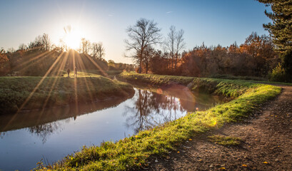 River landscape with hiking trail at sunset on a beautiful autumn evening in Flanders, Belgium. - obrazy, fototapety, plakaty