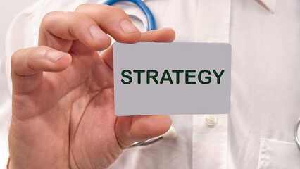 STRATEGY the text on the business card in the hand of a man in a white shirt