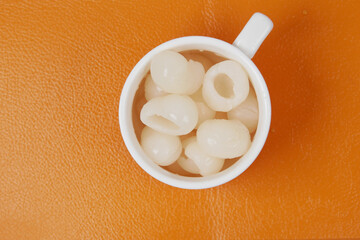 longans fruits in cup on orange background 