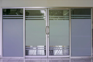Glass or Aluminum door, double swing, clear glass with gray light filter film, door concept, aluminum, glass and home decoration accessories. Soft and selective focus.                