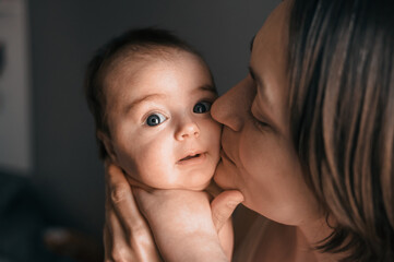 Mom, mummy, young mother with little baby daughter. Breast-feeding. Mum kissing,hugging child. Newborn cute happy girl smiling in woman hands. Family happiness. Age parents, parenting, motherhood
