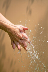 Close up of a female wet hands with water gliding and splashing