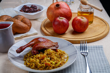 Honey, menorah apples and pomegranates and challah on the Rosh Hashanah table next to it in a plate...