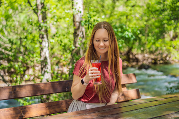 Woman drinking healthy fruits and vegetables juice smoothie in summer. Happy girl enjoying organic drink Portrait of a disgruntled girl sitting at a cafe table