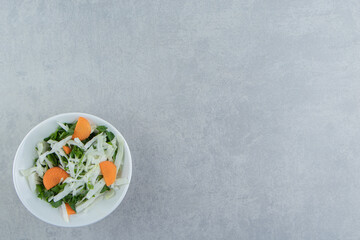 Tasty sliced vegetables in a bowl , on the marble background