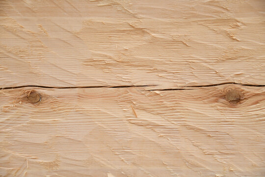 Nahaufnahme vom bebeilten Kiefernholz im Rohzustand als Hintergrund. Die Kiefer ist ein Nadelholz. Das Holz wird mit Leinöl Balsamterpentin gestrichen und somit haltbarer gemacht. 