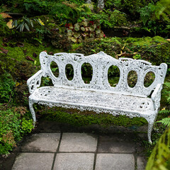 white iron bench in the backyard garden