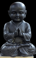 Naklejka premium Jeune bouddha noir sur fond noir 