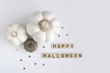 Modern Halloween Flat Lay with White and Brown-Gray Pumpkin, Gold Confetti of Star Shape and Wooden 