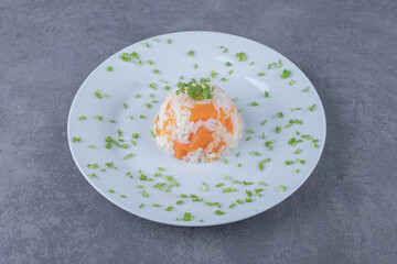 Carrot rice on the plate, on the marble background
