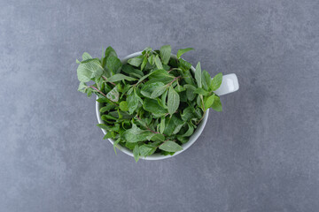 Raw mint in a cup , on the marble background
