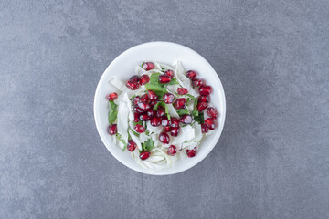 Pomegranate arils and grated vegetable, on the marble background